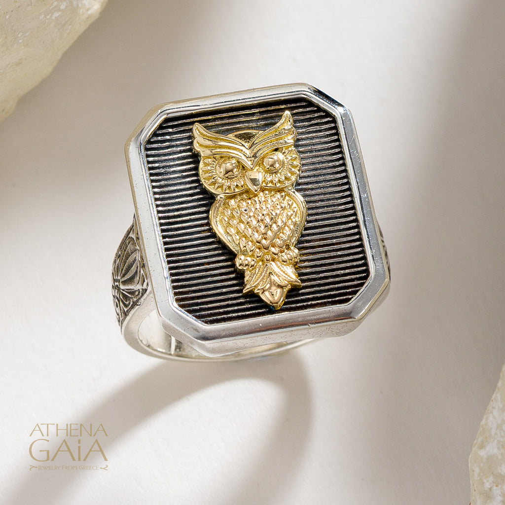 Gold owl design on a silver ring with Athena Gaia branding.