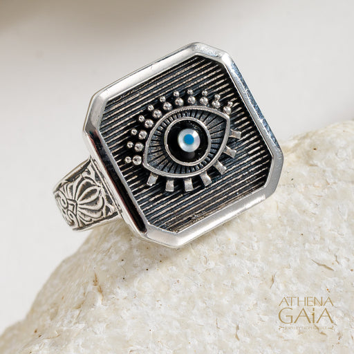 925 Sterling Silver ring with and evil eye design on a stone surface, branded 'Athena Gaia'.
