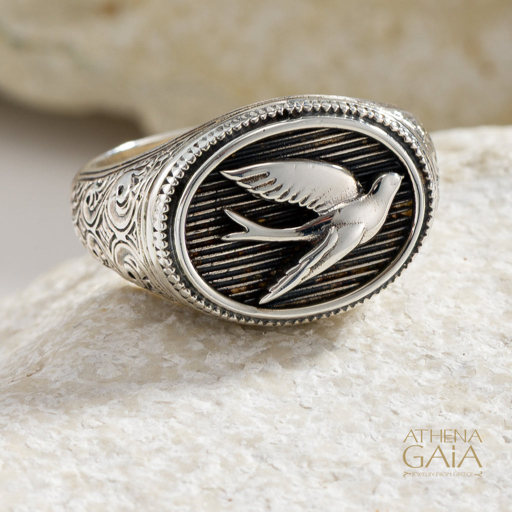 925 Silver oval ring with single swallow bird design on a stone surface, featuring the brand 'Athena Gaia'.