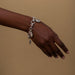 Hand wearing a silver bracelet with charms 