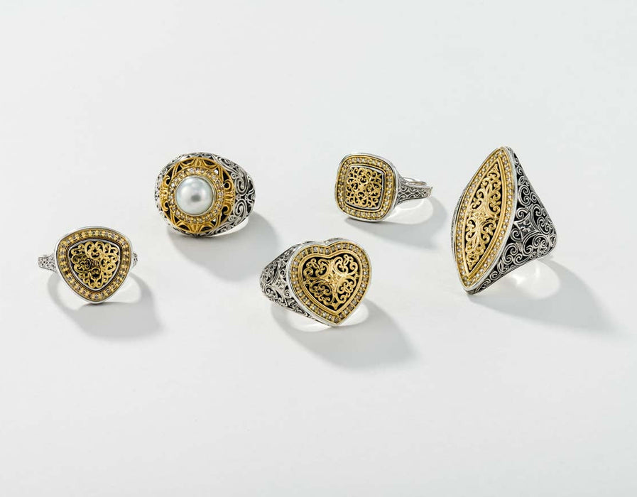 Set of five gold and silver rings on a light gray background