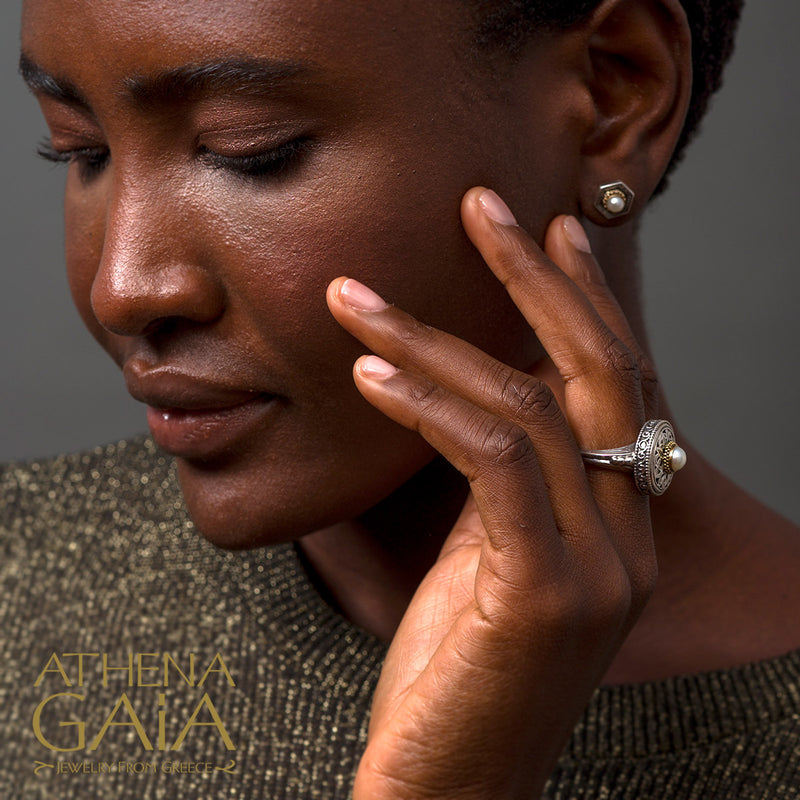 Woman with hand near face, wearing Gerochristo silver earrings and a ring