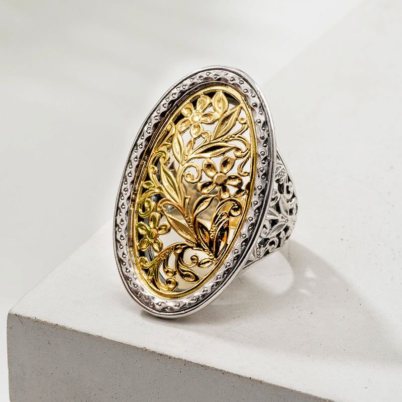A large oval filigree ring with floral patterns on the face and shank