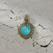 Heart-shaped pendant with a vivid blue stone set in ornate silver and gold detailing against a cracked, textured background