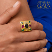 A person wearing a Byzantine Style gold-colored square-shaped ring with multiple smaller stones set within it, on their left hand.