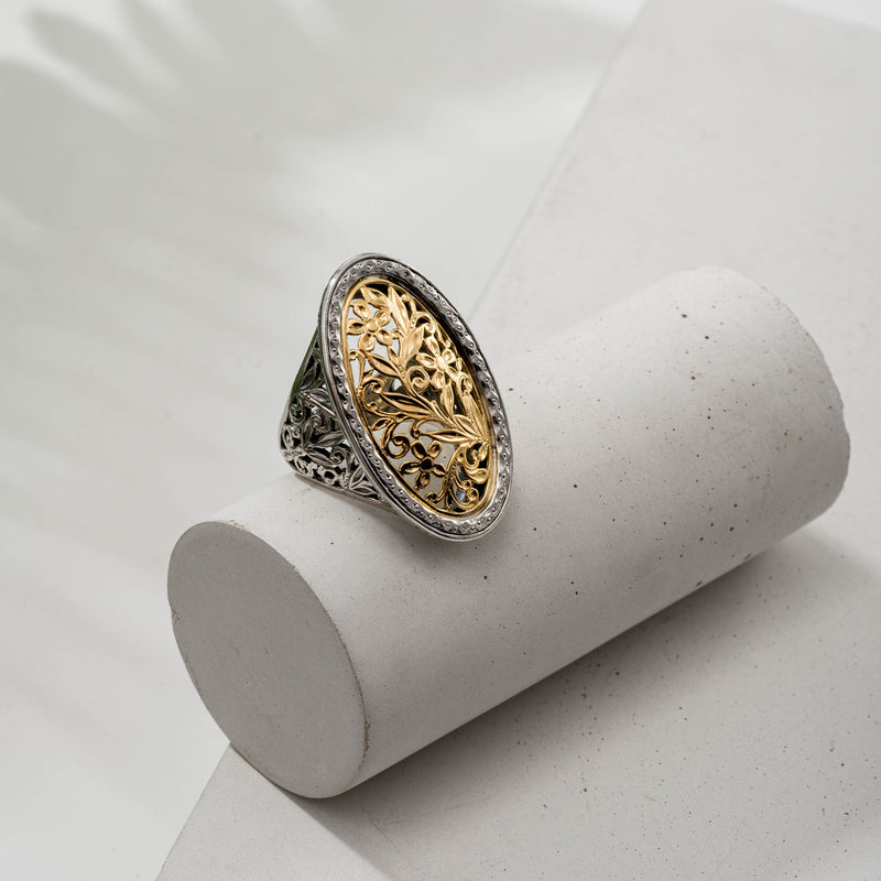 A large oval filigree ring with floral patterns on the face and shank