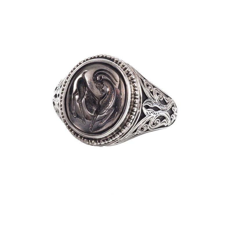 Silver ring with intricate design on a white background