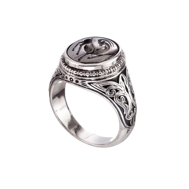 Silver ring with intricate design on a white background