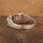 A ring featuring three white pearls set in a sterling silver and solid 18k gold band with intricate embossing.