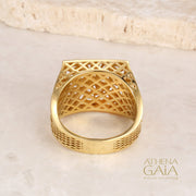 A gold square ring with intricate filigree details and diamonds on a stone with the Athena Gaia Jewelry logo visible.