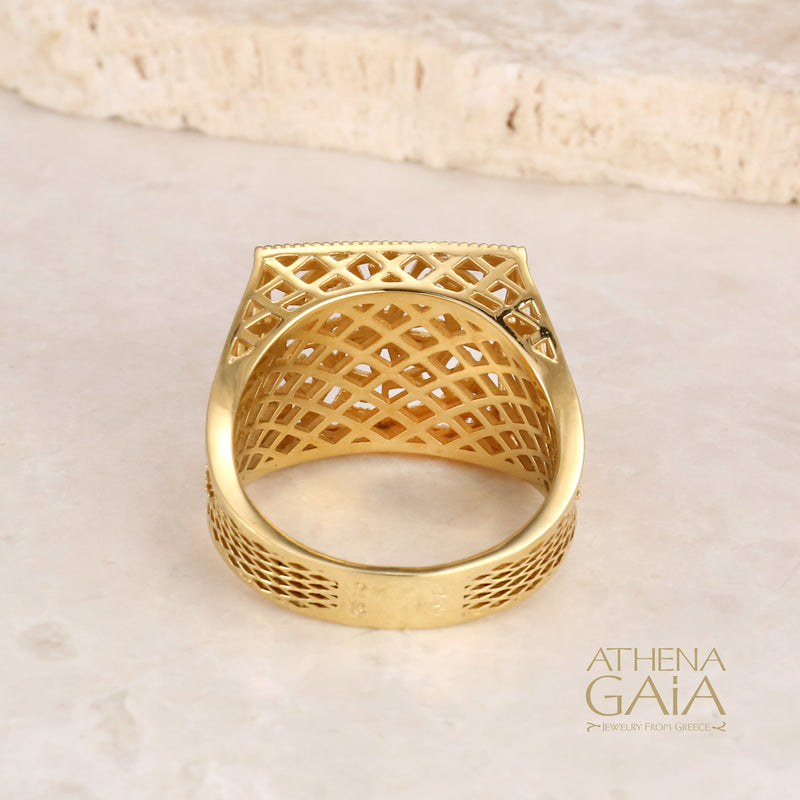 A gold square ring with intricate filigree details and diamonds on a stone with the Athena Gaia Jewelry logo visible.