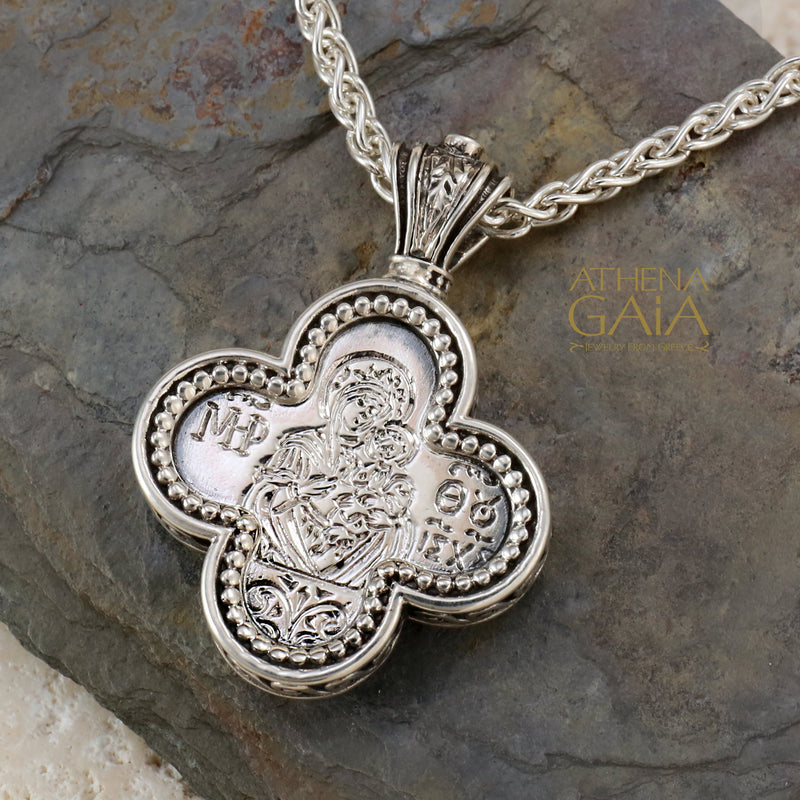 Silver clover shaped pendant featuring a detailed Byzantine style icon on a woven chain necklace.