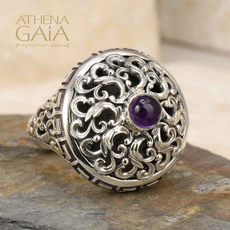 A sterling silver ring with a round amethyst centerpiece, featuring intricate Byzantine-inspired filigree work.