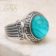 A silver ring with a blue stone featuring Ionic column designs and a Meander Greek key pattern.