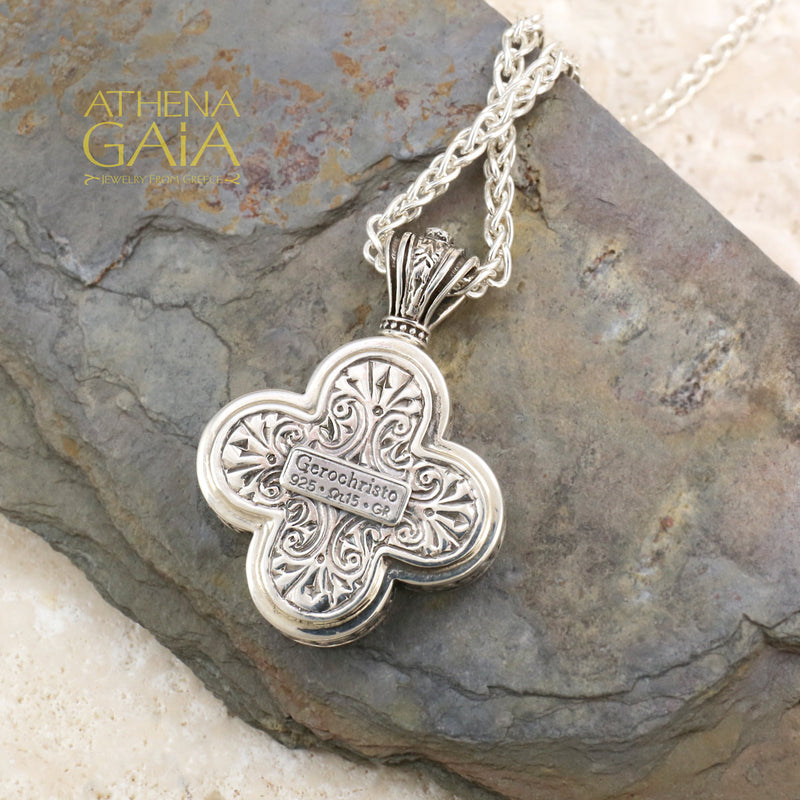 Silver clover shaped pendant featuring a detailed Byzantine style icon on a woven chain necklace.