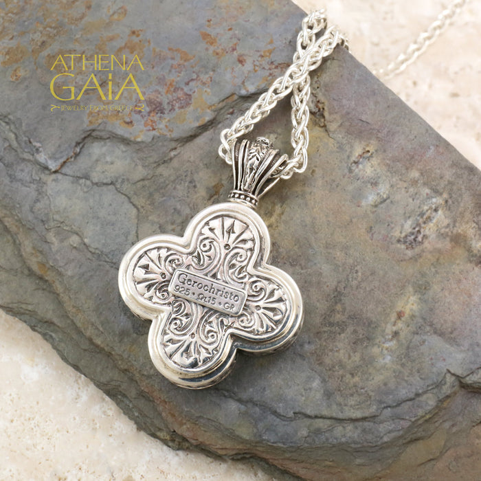 Silver clover shaped pendant featuring a detailed Byzantine style icon on a woven chain necklace.