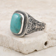 men's Silver ring with turquoise stone on a textured beige surface