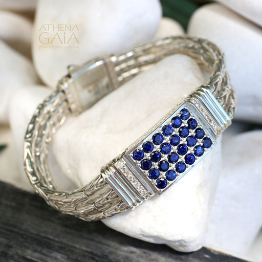 Silver bracelet with blue gemstones on a stone surface