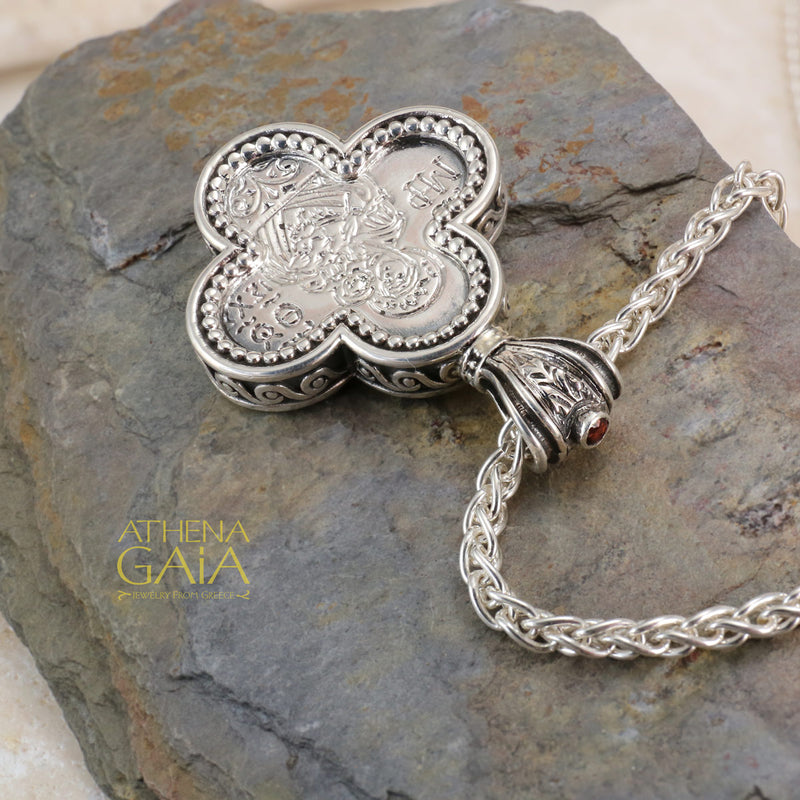 Silver clover shaped pendant featuring a detailed Byzantine style icon on a woven chain necklace.