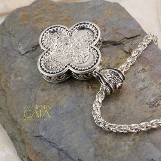 Silver clover shaped pendant featuring a detailed Byzantine style icon on a woven chain necklace.