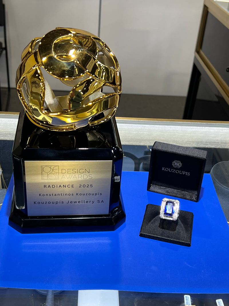 Gold jewelry piece with a black box labeled 'Pandora' on a blue surface.