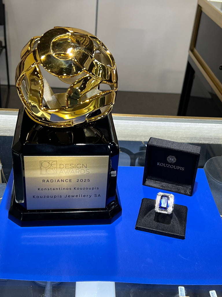 Gold jewelry piece with a black box labeled 'Pandora' on a blue surface.