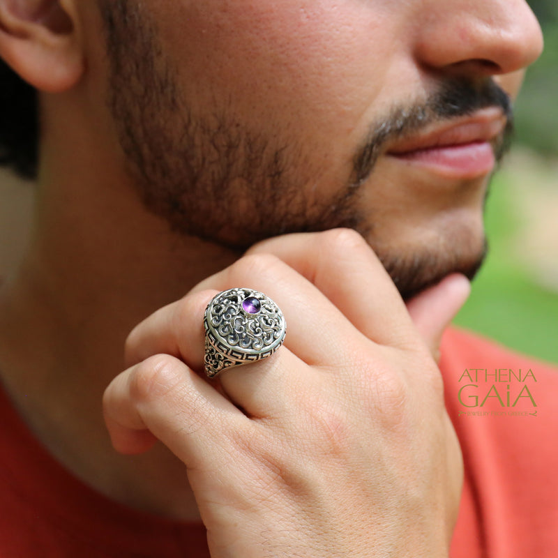 Man wearing a silver ring with an amethyst stone, brand 'Athena Gaia' visible.