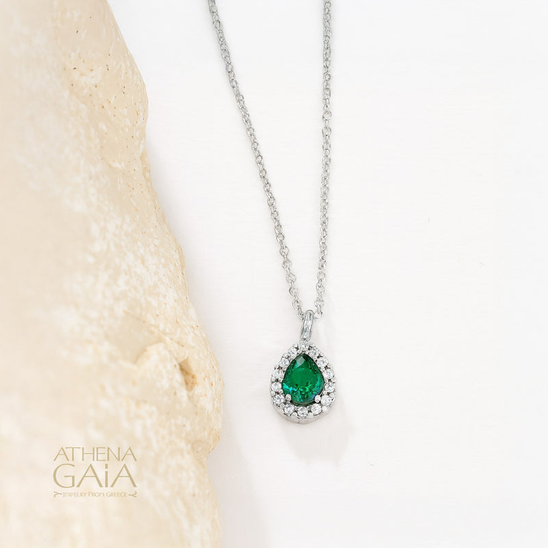 Gold necklace with an emerald green teardrop pendant surrounded by small diamonds.