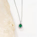 Gold necklace with an emerald green teardrop pendant surrounded by small diamonds.