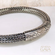 Woven silver bracelet with detailed floral clasp design, handcrafted in Greek artisan style.
