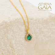 Gold necklace with an emerald green teardrop pendant surrounded by small diamonds.
