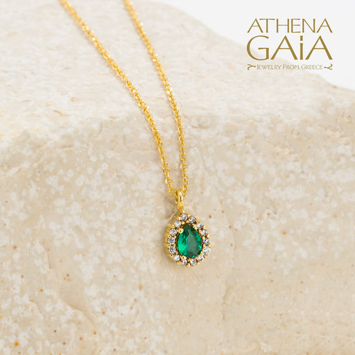 Gold necklace with an emerald green teardrop pendant surrounded by small diamonds.
