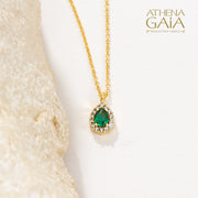 Gold necklace with an emerald green teardrop pendant surrounded by small diamonds.
