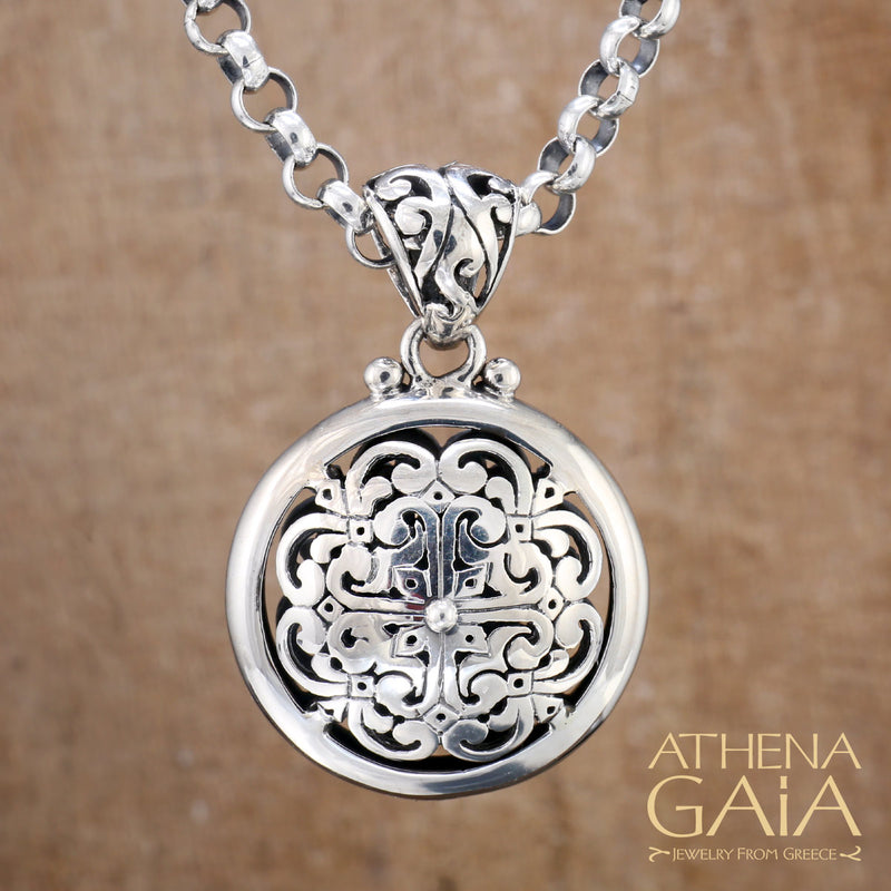 Intricate round silver pendant with ornate filigree design on chain, handmade Greek jewelry