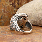 A large silver unisex ring with a floral pattern.