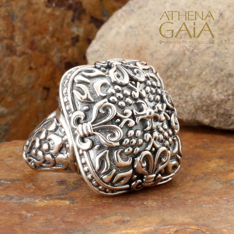 A large silver unisex ring with a floral pattern.
